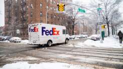 FedEx truck driving through NYC during snowstorm 