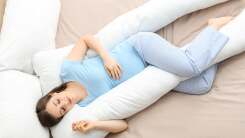 Pregnant person sleeping with pregnancy pillow