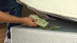 Man putting money under mattress