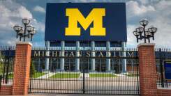 A team logo on a gate outside Michigan Stadium in Ann Arbor, MI