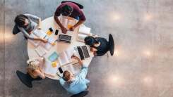 aerial view of five students studying together around a round table