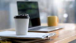 White take-out coffee cup on office desk 