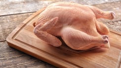 Whole raw turkey on wooden cutting board