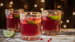 Three glasses of a pomegranate cocktail on a table.