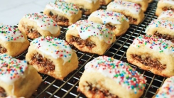 Fig centered cookies with colorful sprinkles on a wire rack.