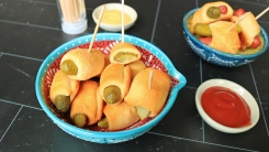 Pickles wrapped in crescent roll dough in a bowl.
