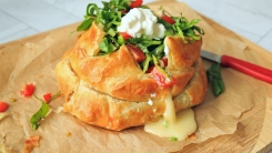 Puff pastry wrapped bried topped with lettuce, tomatoes, and sour cream.
