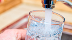 Close up of hand filling glass of tap water at sink