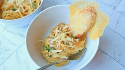 A bowl of pasta with a crouton sticking into the bowl.