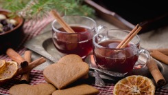 Two glasses of mulled wine next to ginger cookies.
