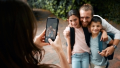 Mom taking picture of family with smartphone