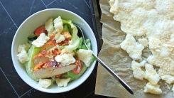 Salad next to a sheet tray of savory meringue.