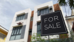 "For sale" sign in front of apartment building 