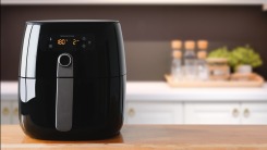 A black air fryer sitting on a countertop