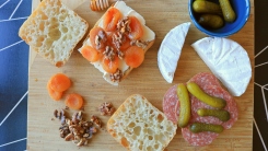 A cheeseboard with open sandwiches and scattered ingredients.