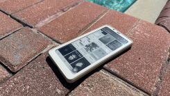 A Boox Palma device sitting on a stone patio with a pool visible in the background