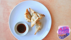 Fried dumplings on a plate with soy sauce.