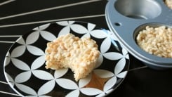 Round rice krispies treat on a black and white plate.