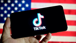 Tiktok logo on smartphone in front of American flag