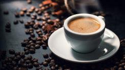 cup of espresso with coffee beans scattered around