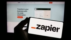 Zapier logo on smartphone and Zapier site on computer monitor