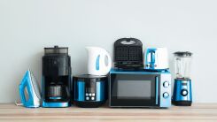 Various smart home appliances (toaster, microwave, waffle iron) sitting next to one another on a counter