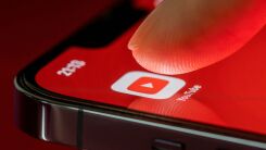 A finger selecting the YouTube app icon on an iphone