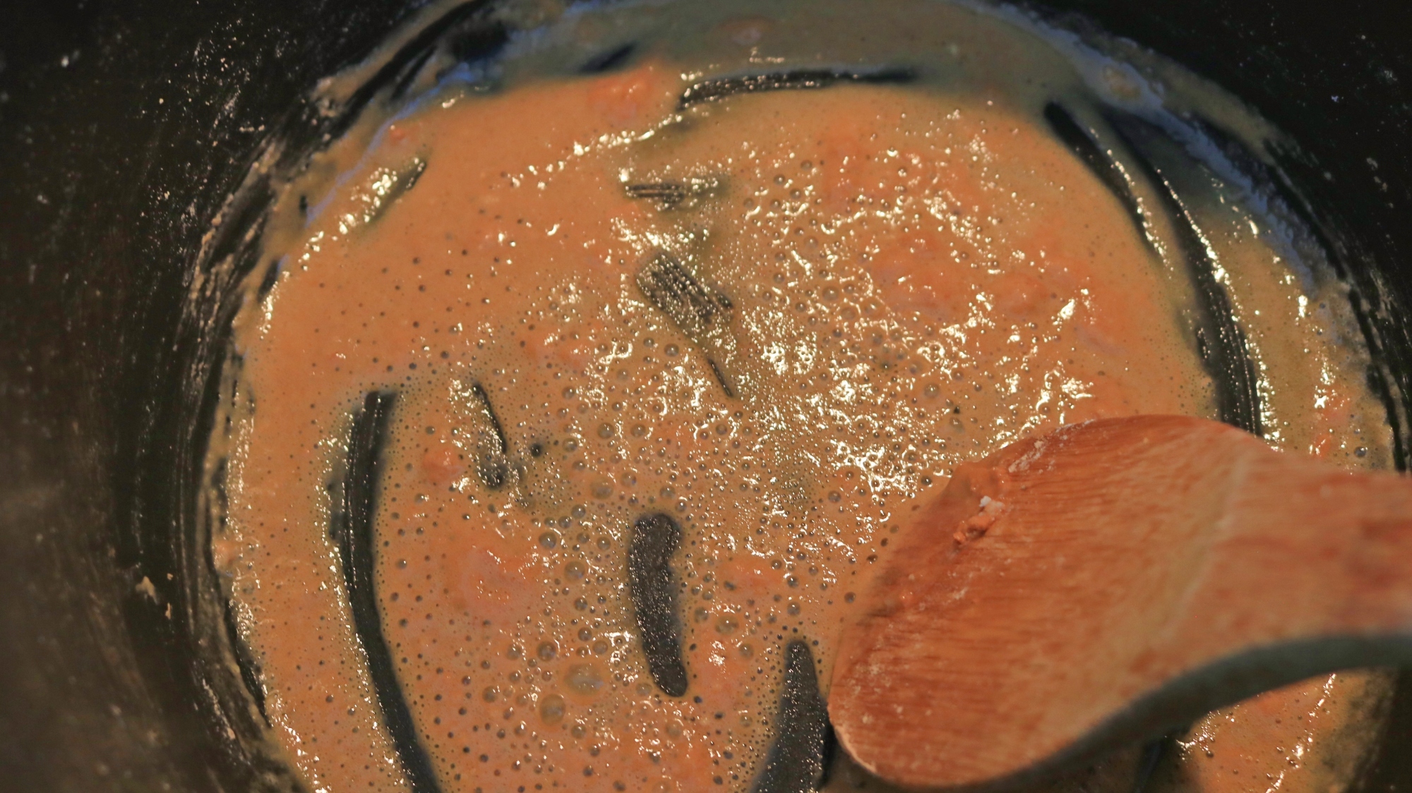 A brown peanut sauce at the bottom of a pot.
