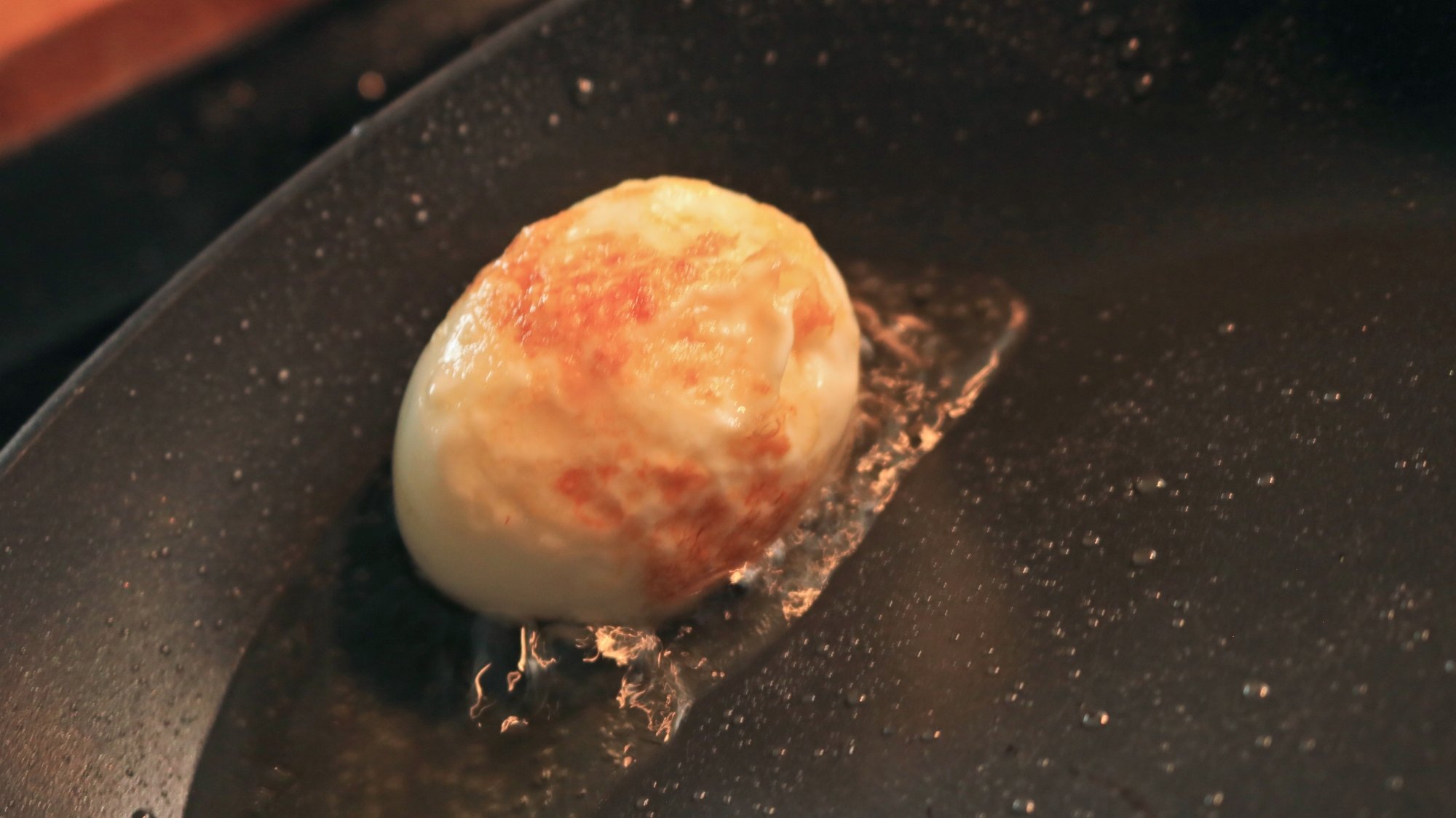 An egg frying in a small pool of oil