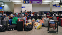 A large number of bags and suitcases near the luggage carousel at an airport