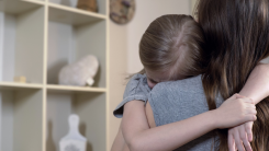 mother hugging and comforting sad young girl