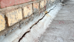 A large crack in a brick home's foundation