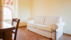 A white fabric couch in a sparse tiled room