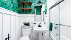 modern bathroom with bright wallpaper, shelves, and plants