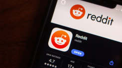 A photograph of a phone displaying the Reddit App Store listing