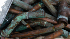 pile of old, corroded copper pipes