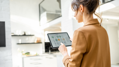 woman using smart home apps on a tablet in a home