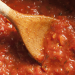 wooden spoon in a pot of traditional italian tomato sauce