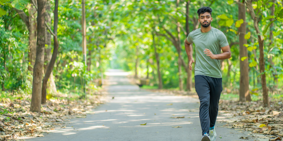 Man jogging, running through the woods